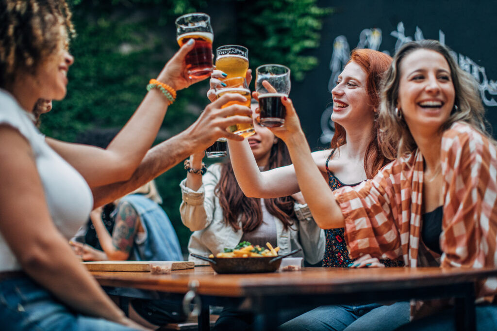 Eine Gruppe Mädchen trinkt Bier und prostet an
