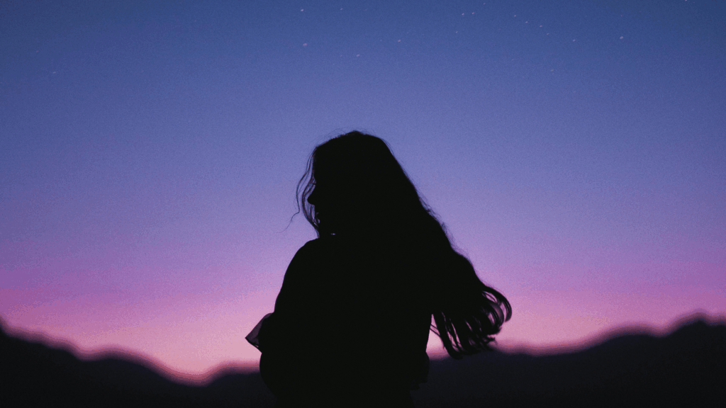 Frau steht vor buntem Sternehimmel