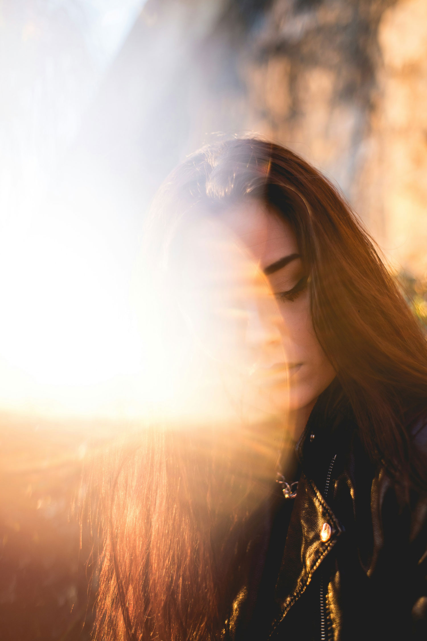 Selbstbild-Gap: Traurige, junge Frau mit Sonnenstrahlen.