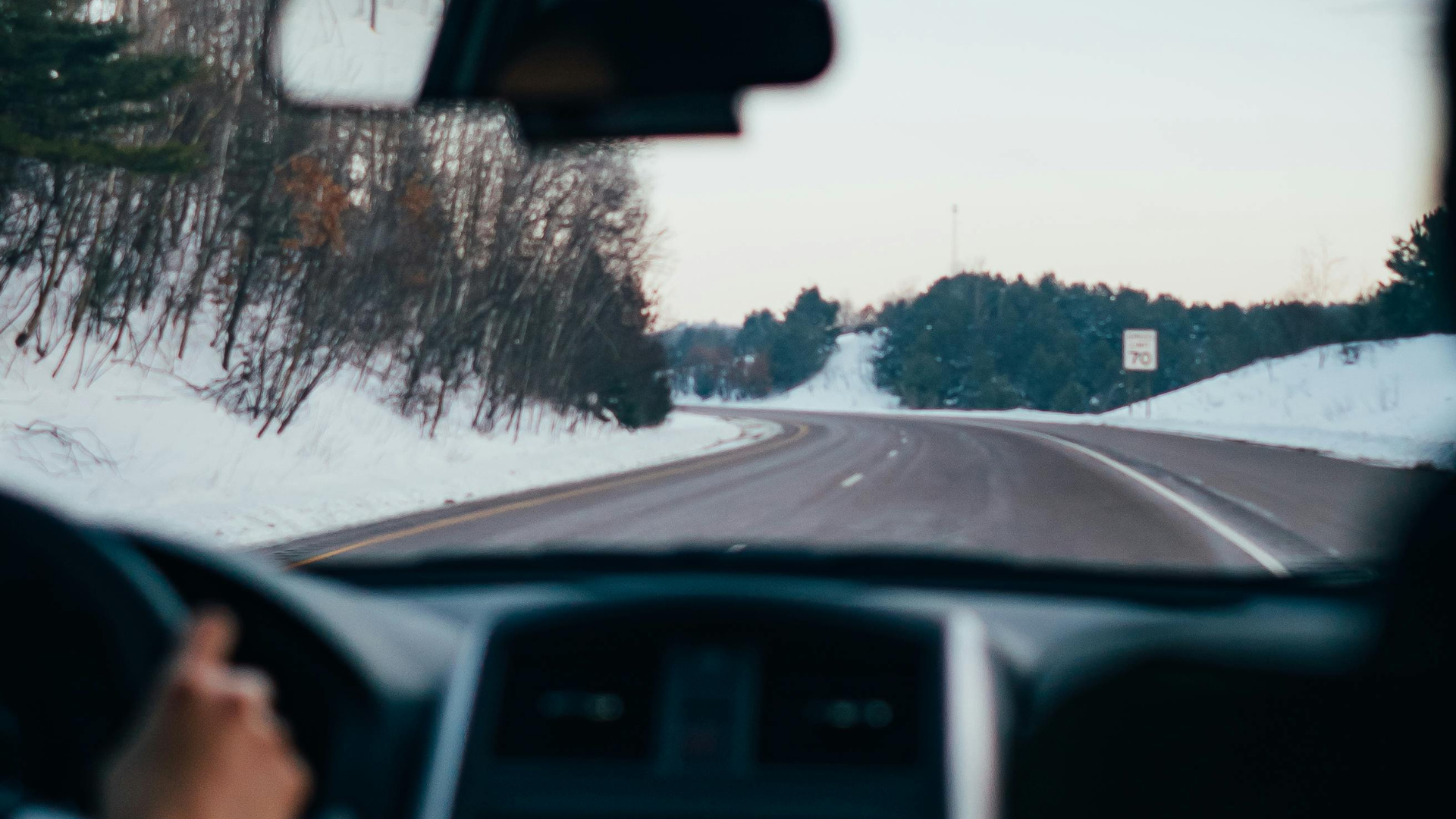 Vom Auto aus sieht mannach außen auf eine Schneefahrbahn