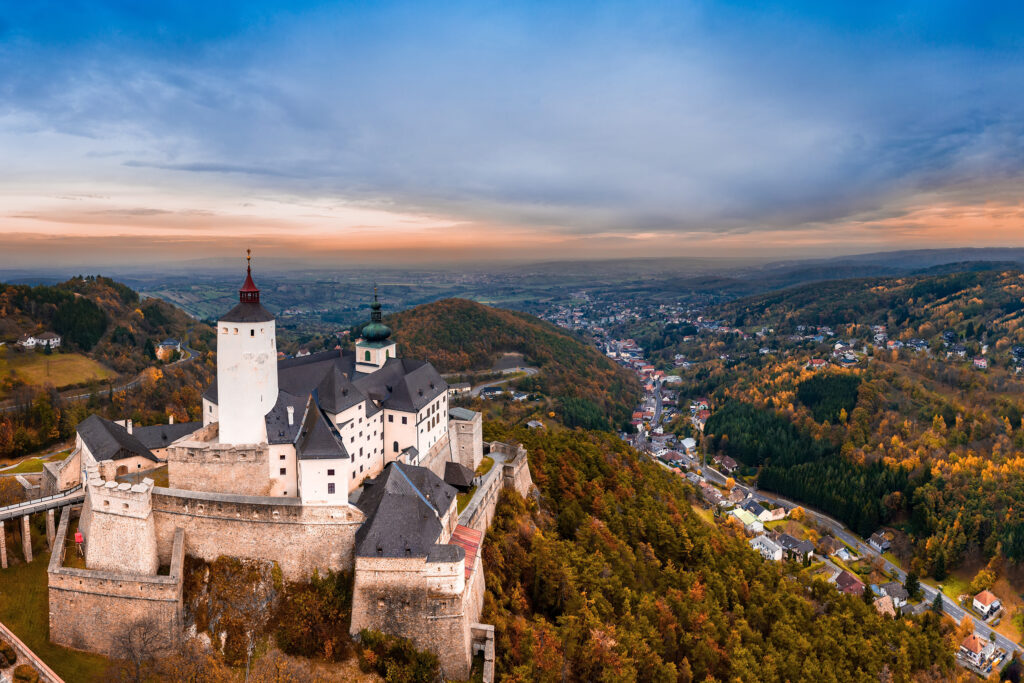 Semesterferien: Historische Burg auf einem Hügel mit Blick über ein herbstliches Tal und ein Dorf
