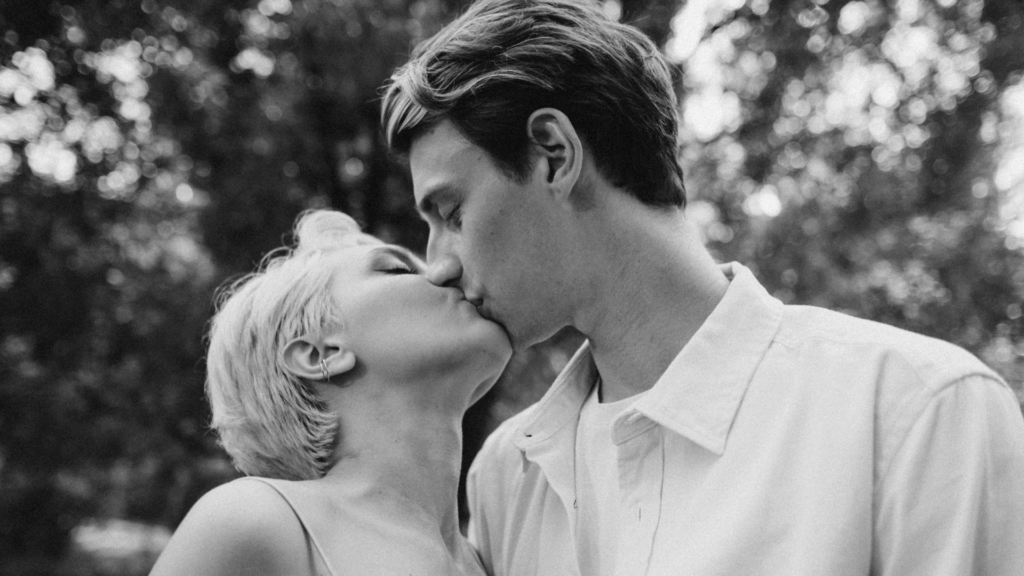 Eine blonde Frau und ein braunhaariger Mann küssen sich