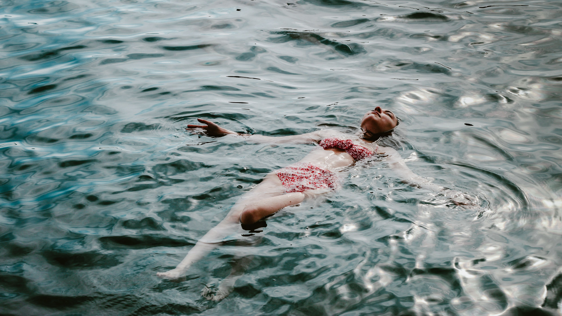 Eine Frau schwimmt auf dem Rücken im Wasser