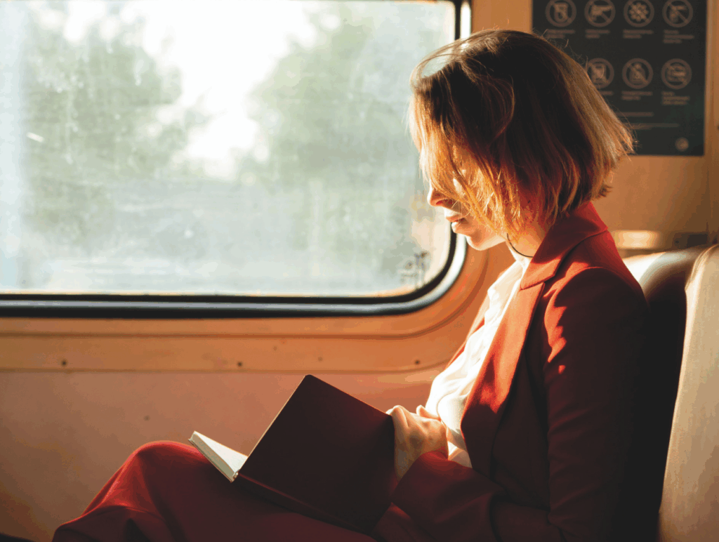 Eine Frau sitzt im Zug und liest